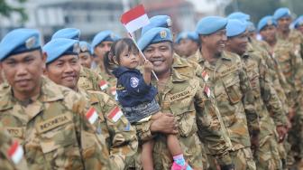 
Seorang prajurit TNI AL yang tergabung dalam Satgas Maritim Task Force (MTF) Konga XXVIII.J UNIFIL menggendong anaknya ketika tiba di Dermaga Ujung Koarmada II Surabaya, Jawa Timur, Kamis (8/11/2018). [ANTARA FOTO/M Risyal Hidayat]