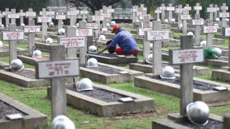 Pekerja membersihkan makam jelang peringatan hari pahlawan di Taman Makam Pahlawan (TMP) Kalibata, Jakarta, Jumat (9/11). [Suara.com/Muhaimin A Untung] 