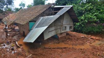 Warga mencari barang yang masih bisa diselamatkan di rumahnya yang tertimbun meterial tanah longsor di Desa Bojongsari, Kabupaten Tasikmalaya, Jawa Barat, Kamis (8/11). [ANTARA FOTO/Adeng Bustomi]