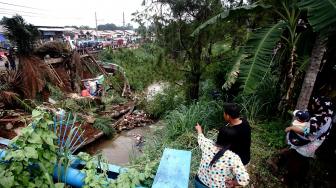 Sejumlah warga melihat jalan longsor di sisi jalan Raya Citayam-Depok, Jawa Barat, Jumat (9/11). [ANTARA FOTO/Kahfie kamaru]