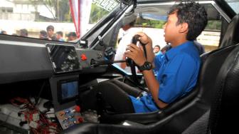 Teknisi saat menggunakan mobil listrik saat uji coba di kantor PLN unit Induk industri PLN, Gambir, Jakarta, Jumat (9/11). (Suara.com/Fakhri Hermansyah)