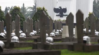 Pekerja membersihkan makam jelang peringatan hari pahlawan di Taman Makam Pahlawan (TMP) Kalibata, Jakarta, Jumat (9/11). [Suara.com/Muhaimin A Untung] 