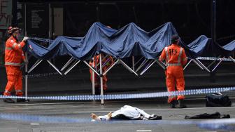 Personil Layanan Darurat Negara Bagian (SES) mendirikan tenda didekat mayat yang berada di TKP insiden penikaman di Melbourne, Australia, Jumat (9/11). [AFP/William West]