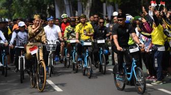 Presiden Joko Widodo mengenakan baju pejuang Bung Tomo (tengah) didampingi Kepala Staf Presiden Moeldoko (kiri) dan Gubernur Jawa Barat Ridwan Kamil (kedua kanan) menyapa warga ketika mengikuti kegiatan sepeda bersama dengan tema Bandung Lautan Sepeda di Bandung, Jawa Barat, Sabtu (10/11/2018). ANTARA FOTO/Wahyu Putro A