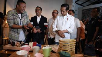 
Calon Presiden Nomor Urut 01 Joko Widodo (kanan) didampingi Gubernur Jawa Barat Ridwan Kamil (kedua kiri) mencoba memakai jam yang dipamerkan sebelum berdiskusi dengan masyarakat kreatif Bandung di Simpul Space, Bandung, Jawa Barat, Sabtu (10/11). [ANTARA FOTO/Wahyu Putro]