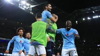 Gelandang Manchester City Ilkay Gundogan merayakan golnya setelah mencetak gol ketiga mereka ke gawang Manchester United selama pertandingan sepak bola Liga Premier Inggris antara Manchester City melawan Manchester United di Etihad Stadium, Manchester, Inggris, Minggu (11/11). [AFP/Lindsey PARNABY]