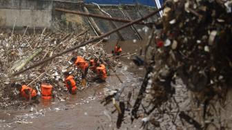 Petugas kebersihan DKI Jakarta membersihkan sampah di pintu air Manggarai, Jakarta Selatan, Senin (12/11). [Suara.com/Muhaimin A Untung] 