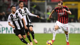 Pemain depan AC Milan Gonzalo Higuain melewati pemain tengah Juventus Miralem Pjanic dan gelandang Juventus Rodrigo Bentancur selama pertandingan sepak bola Serie A Italia AC Milan melawan Juventus di Stadion San Siro, Milan, Italia, Senin (12/11). [AFP/Marco BERTORELLO]