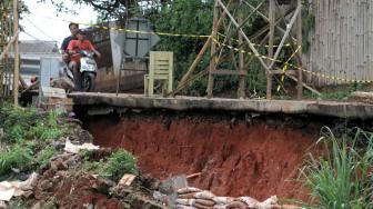 Suasana tanah longsor di Jalan Tiu yang berdekatan dengan pintu air sunter hulu daerah Setu Cipayung, Jakarta Timur, Senin (12/11). (Suara.com/Fakhri Hermansyah)