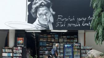 Seorang melintas di depan mural tokoh Huri Adam di Gedung Taman Ismail Marzuki, Jakarta, Senin (12/10). [Suara.com/Muhaimin A Untung] 