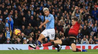 Penyerang Manchester City Sergio Aguero mencetak gol usai melewati pemain belakang Manchester United Victor Lindelof selama pertandingan sepak bola Liga Premier Inggris antara Manchester City melawan Manchester United di Etihad Stadium, Manchester, Inggris, Minggu (11/11). [AFP/Lindsey PARNABY]