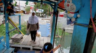 Warga menaiki perahu eretan yang ingin menyeberangi Kali Sunter di Rawa Badak, Jakarta Utara, Rabu (14/11).  (Suara.com/Fakhri Hermansyah)