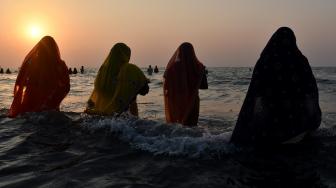 Umat ​​Hindu India berdoa di laut selama festival Chhath Puja di Mumbai, India, Selasa (13/11). [AFP/ PUNIT PARANJPE]