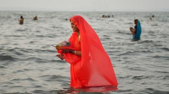 Umat ​​Hindu India berdoa di laut selama festival Chhath Puja di Mumbai, India, Selasa (13/11). [AFP/ PUNIT PARANJPE]