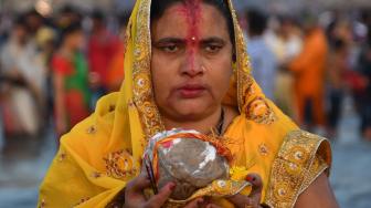 Umat ​​Hindu India berdoa di laut selama festival Chhath Puja di Mumbai, India, Selasa (13/11). [AFP/ PUNIT PARANJPE]