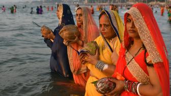 Umat ​​Hindu India berdoa di laut selama festival Chhath Puja di Mumbai, India, Selasa (13/11). [AFP/ PUNIT PARANJPE]