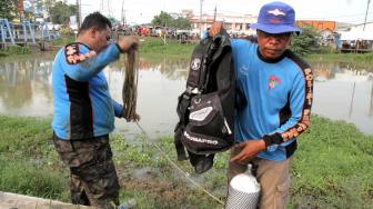 Pencarian barang bukti linggis yang digunakan tersangka kasus pembunuhan Haris Simamora di Aliran Kalimalang, Cikarang, Jawa Barat, Sabtu (17/11).(Suara.com/Fakhri Hermansyah)