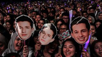 Sejumlah penonton bernyanyi sambil memegang poster penyanyi Amerika Serikat Charlie Puth tampil  di ICE BSD, Tangerang, Banten, Jumat (16/11). (Suara.com/Fakhri Hermansyah)