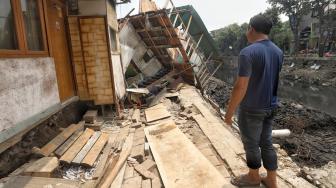 Sejumlah pekerja memperbaiki rumah yang rusak akibat terdampak longsor pada turap anak Kali Ciliwung di Jalan Kerapu, Ancol, Jakarta Utara, Rabu (21/11). [Suara.com/Muhaimin A Untung]