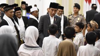 Presiden Joko Widodo (tengah) menyapa sejumlah anak yatim yang turut menghadiri Peringatan Maulid Nabi Muhammad SAW 1440 Hijriah/2018 Masehi di Istana Bogor, Jawa Barat, Rabu (21/11). [ANTARA FOTO/Puspa Perwitasar]