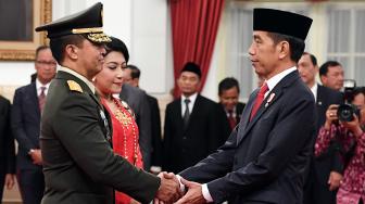 Presiden Joko Widodo (kanan) memberi ucapan selamat kepada Kepala Staf Angkatan Darat (KSAD) yang baru Jenderal TNI Andika Perkasa (kiri) seusai pelantikan di Istana Merdeka, Jakarta, Kamis (22/11). [ANTARA FOTO/Wahyu Putro ]