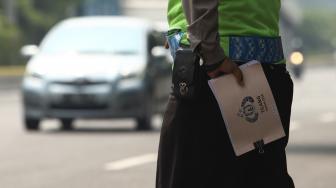 Petugas gabungan dari Badan Pajak dan Retribusi Daerah, Polisi Satuan Lalu Lintas Polda Metro, serta Jasa Raharja menggelar razia pajak di Jalan Kramat Raya, Jakarta Pusat, Kamis (22/11). [Suara.com/Muhaimin A Untung]
