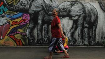 Warga melintas disamping mural 3D di tembok rumah warga daerah Jagakarsa, Jakarta Selatan, Minggu (25/11). (Suara.com/Fakhri Hermansyah)