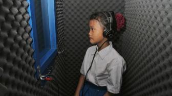 Siswa Sekolah saat diperiksa menggunakan mesin Chamber Booth (Ruang Kedap Suara Audiometer) di Pademangan Jakarta Utara, Senin (26/11). (Suara.com/Fakhri Hermansyah)