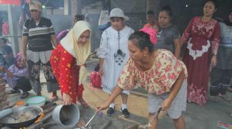 Ibu guru Rossi mengajarkan saat membantu ibu-ibu memasak untuk konsumsi acara di Sekolah  Kartini Kampung Lodan, Jakarta Utara, Senin (26/11). (Suara.com/Fakhri Hermansyah)