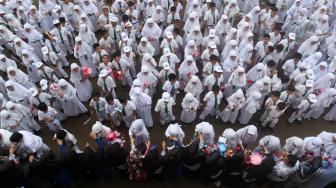 Sejumlah murid sekolah dasar memberikan bunga pada gurunya saat memperingati hari guru Nasional, di Sekolah Al Azhar, Padang, Sumatera Barat, Senin (26/11). ANTARA FOTO/Muhammad Arif Pribadi