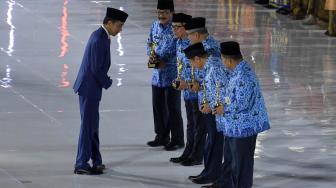 Presiden Joko Widodo (kiri) menyerahkan penghargaan KORPRI Award pada peringatan Hari Ulang Tahun Korps Pegawai Republik Indonesia (KORPRI) ke-47 di Istora Senayan, Jakarta, Kamis (29/11). ANTARA FOTO/Puspa Perwitasari