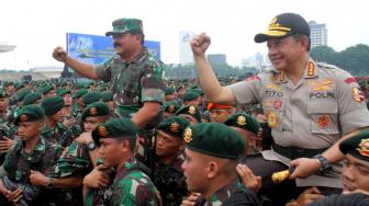 Panglima TNI Marsekal  Hadi Tjahjanto bersama Kapolri Jenderal Tito Karnavian digendong anggota TNI saat  apel  pengamanan Natal, Tahun Baru, Pileg dan Pilpres 2019 di Monas, Jumat (30/11). (Suara.com/Fakhri Hermansyah)