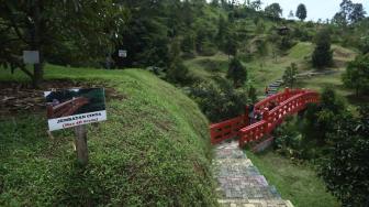 Seorang warga berkunjung di Kawasan Wisata Cikaret Pongkor, kabupaten Bogor, Jawa Barat, Jumat (30/11). [Suara.com/Muhaimin A Untung]