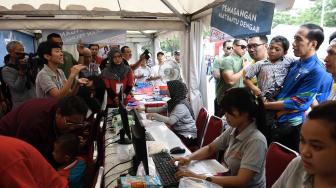 Presiden Joko Widodo (kiri) menggendong siswa penyandang disabilitas asal Sukabumi Mukhlis Abdul Holik disela Peringatan Hari Disabilitas Internasional Tahun 2018 di Bekasi, Jawa Barat, Senin (3/12). [ANTARA FOTO/Puspa Perwitasari]