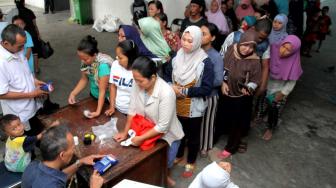 Suasana warga mengantri untuk membeli sembako murah di Pasar Teluk Gong, Jakarta Utara, Senin (3/12).(Suara.com/Fakhri Hermansyah)