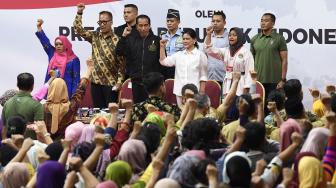 Presiden Joko Widodo (tengah) didampingi Ibu Negara Iriana Joko Widodo (keempat kanan) dan Menteri Sosial Agus Gumiwang Kartasasmita (kedua kiri) bernyanyi bersama penerima dan pendamping Program Keluarga Harapan (PKH) di Gelanggang Remaja Jakarta Timur, Jakarta, Senin (3/12). [ANTARA FOTO/Puspa Perwitasari]
