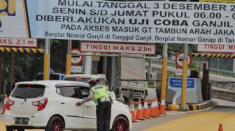 Petugas gabungan saat penerapan sistem Ganjil-Genap dari gerbang  Tol Tambun di Bekasi, Jawa Barat, Selasa (4/12).(Suara.com/Fakhri Hermansyah)