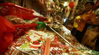 Pembeli memilih pernak-pernik Natal yang dijual di Pasar Asemka, Jakarta, Selasa (4/12). [Suara.com/Muhaimin A Untung]