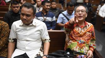 Terdakwa kasus korupsi KTP Elektronik Made Oka Masagung (kanan) dan Irvanto Hendra Pambudi (kiri) bersiap menjalani sidang pembacaan putusan di Pengadilan Tipikor, Jakarta, Rabu (5/12). [ANTARA FOTO/Akbar Nugroho Gumay]