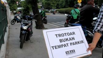 Aktivis Koalisi Pejalan Kaki  melakukan aksi di sepanjang trotoar Jl. I Gusti Ngurah rai,  Jakarta Timur, Jumat (7/12). [Suara.com/Fakhri Hermansyah]