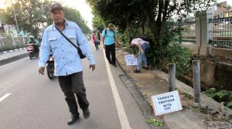 Aktivis Koalisi Pejalan Kaki  melakukan aksi di sepanjang trotoar Jl. I Gusti Ngurah rai,  Jakarta Timur, Jumat (7/12). [Suara.com/Fakhri Hermansyah]