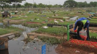 Warga berziarah ke makam keluarga di pemakaman yang terendam banjir di daerah Semper, Jakarta Utara, Sabtu (8/12). (Suara.com/Fakhri Hermansyah)