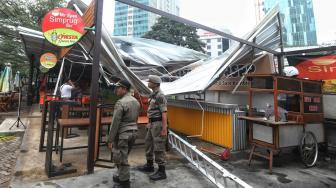 Petugas satpol PP melihat bangunan roboh di Rasuna Garden, Epicentrum Kuningan,  Jakarta, Senin (10/12). [Suara.com/Muhaimin A Untung]