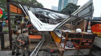 Petugas satpol PP melihat bangunan roboh di Rasuna Garden, Epicentrum Kuningan,  Jakarta, Senin (10/12). [Suara.com/Muhaimin A Untung]