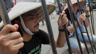 Sejumlah massa aksi bersama Wahana Lingkungan Hidup Indonesia (Walhi) saat unjuk rasa menolak kriminalisasi di depan Istana Negara, Jakarta Pusat, Kamis (11/12).[Suara.com/Fakhri Hermansyah]