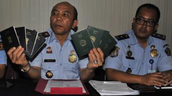 

Kepala Kantor Imigrasi Kelas I Serang Syamsul (kiri) didampingi Kasi Penindakan Aulia Kusdinar (kanan) memperlihatkan paspor para turis yang tersesat di Perairan Banten, Senin (10/12). [ANTARA FOTO/Asep Fathulrahman]