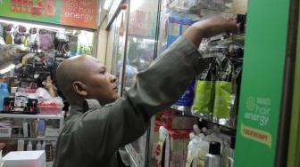 Petugas  gabungan Badan Pengawas Obat dan Makanan (BPOM) bersama Satpol  PP Jakarta  memeriksa kosmetik impor saat inspeksi mendadak di pertokoan Pasar Baru, Jakarta Pusat, Rabu (12/12). [Suara.com/Fakhri Hermansyah]