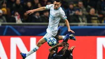 Gelandang Inter Milan Kwadwo Asamoah jatuh saat menghadang pemain depan PSV Eindhoven, Hirving Lozano selama pertandingan grup B Liga Champions di Stadion San Siro, Milan, Italia, Rabu (12/12). [Miguel MEDINA / AFP]