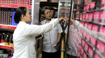 Petugas  gabungan Badan Pengawas Obat dan Makanan (BPOM) bersama Satpol  PP Jakarta  memeriksa kosmetik impor saat inspeksi mendadak di pertokoan Pasar Baru, Jakarta Pusat, Rabu (12/12). [Suara.com/Fakhri Hermansyah]