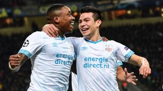 Pemain depan PSV Eindhoven Hirving Lozano merayakan golnya dengan pemain depan PSV Eindhoven, Steven Bergwijn selama pertandingan Liga Champions grup B Inter Milan melawan PSV Eindhoven di Stadion San Siro, Milan, Italia, Rabu (12/12). [Miguel MEDINA / AFP]